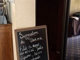 a blackboard sign in the corner of a room next to a bed