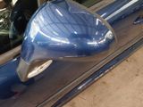 a picture of a blue car with a mirror on the side of it