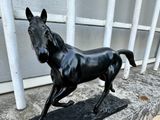 a statue of a horse that is standing on a ledge