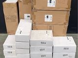 des cartons empilés sur une palette devant un mur noir