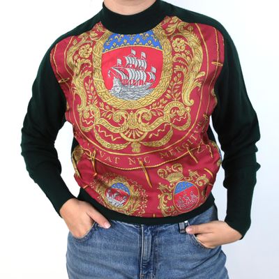 a woman wearing a sweater that has a picture of a ship on it