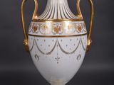 a white vase with gold decoration on it on a black background