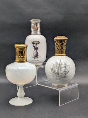 trois vases en verre blanc posés sur un socle transparent