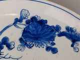 a blue and white plate with a bird and flowers on it