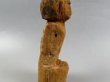 a wooden sculpture of a person sitting on top of a tree stump