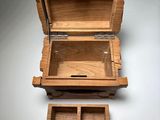 an open wooden box sitting on top of a table next to a drawer