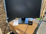 un écran d'ordinateur posé sur un bureau en bois