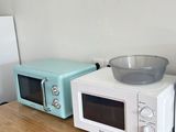 trois micro-ondes posés sur une table, avec un saladier posé dessus