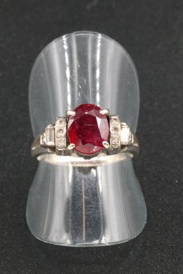 an image of a ring with a red stone in it