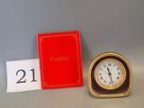 a clock sitting next to a red book on a table