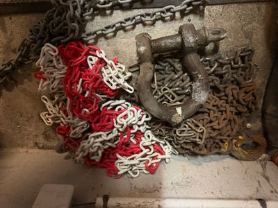 un tas de chaînes et une ancre posés par terre
