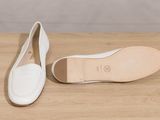 the white shoes are sitting on a wooden surface