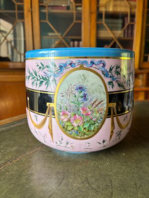 a pink bowl with a blue lid sitting on a table