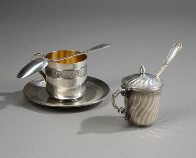 une tasse et une soucoupe en argent, avec une cuillère posée sur la soucoupe