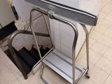a small metal step stool in the corner of a bathroom