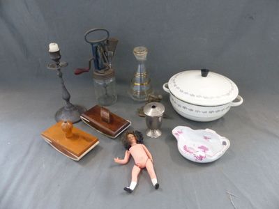une poupée posée sur une table à côté d'autres objets