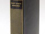 a black book sitting on top of a white table next to a white wall