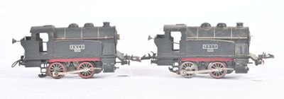 two toy trains sitting side by side on a white surface