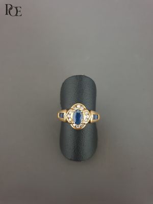 gros plan d'une bague en or avec une pierre bleue