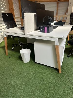 a desk with two computers and a chair in the room