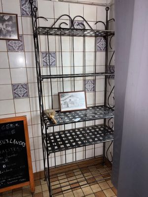 une étagère dans un coin de la salle de bains, avec un tableau noir