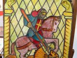 painting of a man riding a horse in a stained glass window