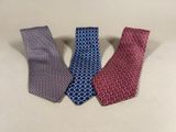 three different colored ties sitting on top of a table