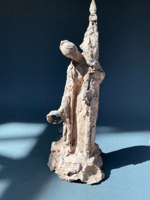 une statue représentant un homme et une femme sur un fond bleu