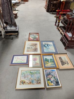 beaucoup de photos encadrées par terre dans un magasin