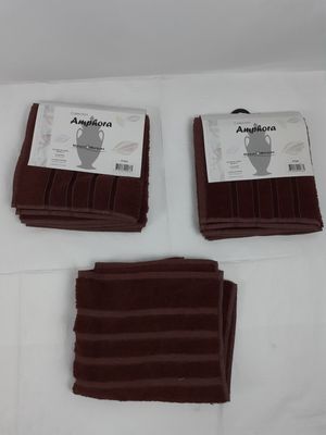Trois serviettes marron sont posées sur une nappe blanche