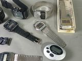 many electronic watches and other electronic gadgets laid out on a table