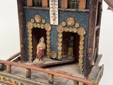 a small wooden house with a bird on the porch