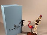 a figurine of a man riding a flamingo next to a box