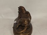 a bronze statue of a dog and a cat on a rock