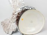 a white vase with a bird decoration on it