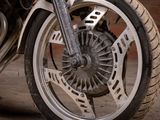 a close up of a motorcycle wheel with a brick wall in the background