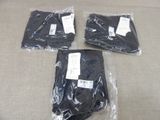 three bags of black clothing sitting on top of a table