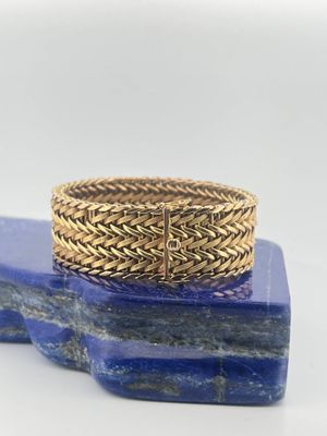 a close up of a gold ring on a blue marble block