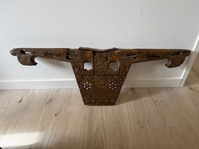 an old wooden shelf with a carved design on it