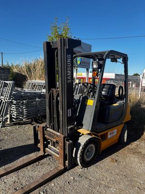 a forklift truck that is parked in the dirt