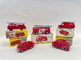 several toy fire trucks are lined up in a row on a white surface