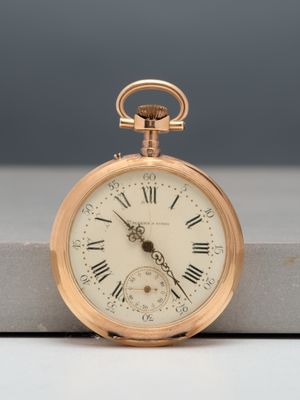 a gold pocket watch with roman numerals on it