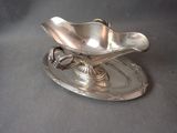 a silver plate with a flower on it on a table