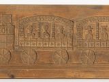 an old wooden plaque with carvings on it on a white surface