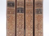three old books sitting on top of each other on a white surface
