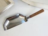 une assiette en argent avec un manche en bois à côté d'une assiette en argent avec un manche en bois