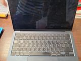 a laptop computer sitting on a desk with a person in the background