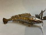 a metal fish that is sitting on a table