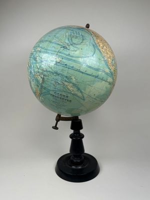 a small blue and green globe on a black stand
