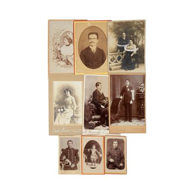 Plusieurs vieilles photos de personnes sont exposées sur une surface blanche